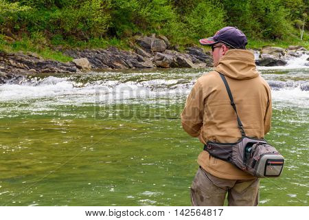 Fishing on the mountain river. Trout fishing. Fisherman fishing in the mountains