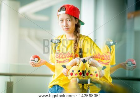 BANGKOK THAILAND – August 142016: Trainer girl playing pokemon pokemon ball Lighting with sun flare