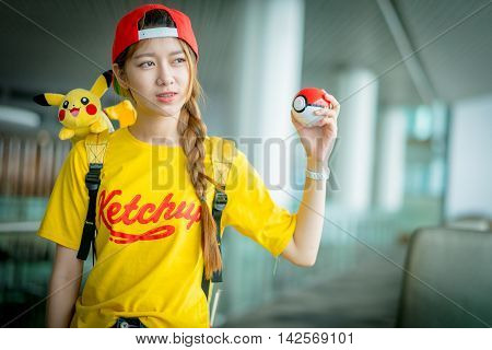 BANGKOK THAILAND – August 142016: Trainer girl playing pokemon pokemon ball Lighting with sun flare