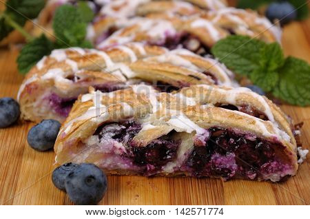 Pie stuffed with cheese cream blueberry crushed peanuts dough braided plait