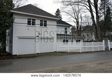WEQUETONSING, MICHIGAN / UNITED STATES - DECEMBER 22, 2015: A white home with an attached two-door garage on Beach Road in Wequetonsing, Michigan.