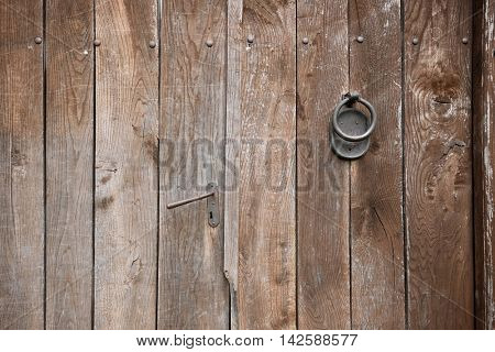 handle and knocker on weathered wooden door, Serbia