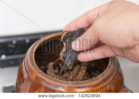 putting herbal to an enamel pot to decoct herbal medicine