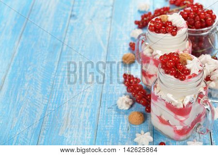 Dessert with red currant and whipped cream on a vintage background