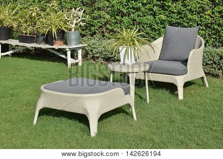 green garden with an outdoor furniture lounge group with rattan chairs sofa and table