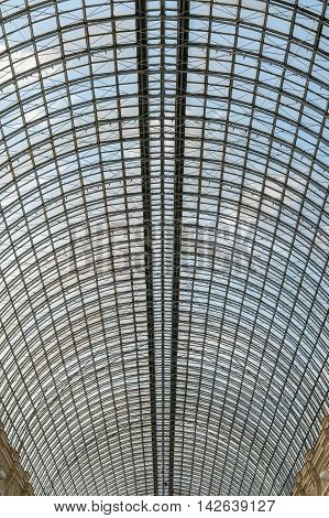 Transparent glass roof arch type reinforced with a metal grate over the huge room