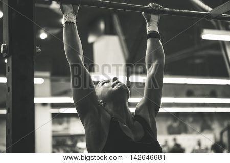 woman doing lifting up on the gym bar