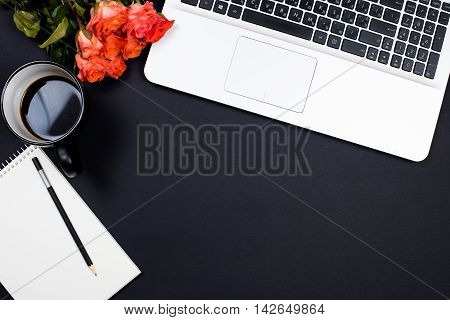 Businessman desk workspace with laptop keyboard, coffee and notepad on black background. Startup concept, top view mockup.