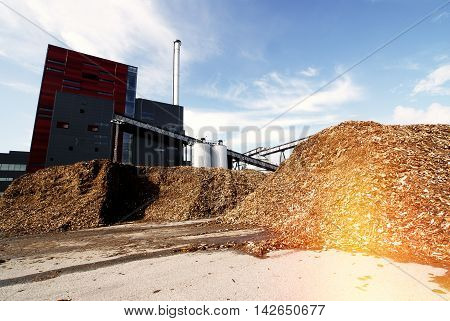 Bio Power Plant With Storage Of Wooden Fuel Against Blue Sky
