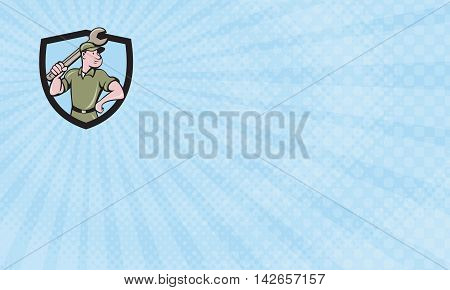 Business card showing Illustration of a mechanic wielding holding spanner wrench looking to the side with one hand on hips viewed from front set inside shield crest on isolated background done in cartoon style.
