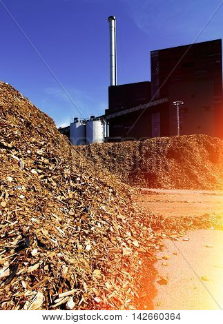Bio Power Plant With Storage Of Wooden Fuel Against Blue Sky