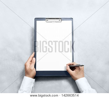 Hand signing blank clipboard with white a4 paper design mockup. Clear document holder mock up template hold arm. Clip board notepad surface display front. Checklist tablet plan file presentation.