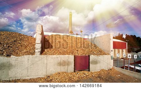 Bio Power Plant With Storage Of Wooden Fuel Against Blue Sky