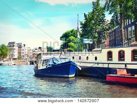 Canal at Amsterdam city, Amstel river with houseboat.