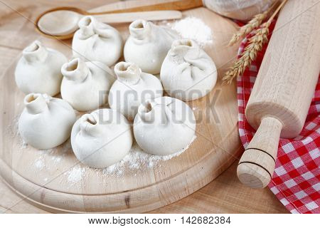 Baking ingredients for cooking manti dumplings on a wooden board.
