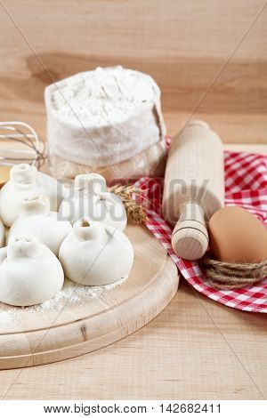 Baking ingredients for cooking manti dumplings on a wooden board.