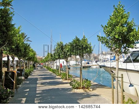 Alcudia Majorca Spain - June 26 2008: Habor promenade of Alcudia with restaurants on the left and boats on the right