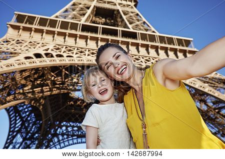 Happy Mother And Child Taking Selfie In Front Of Eiffel Tower