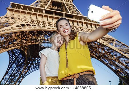 Mother And Child Tourists Taking Selfie Against Eiffel Tower