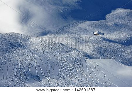 Winter scene in Stoos Swiss Alps. Ski area. Ski and snowboard tracks in powder snow.