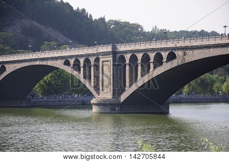 The stone Longmen bridge over the Yi River at Longmen Grottoes in Luoyang China in henan province.