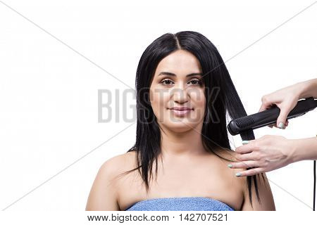 Young woman getting hair straightner isolated on white