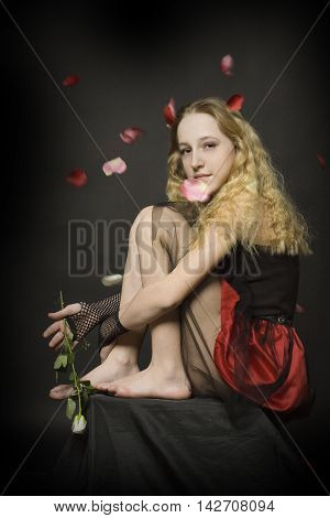 Young girl with rose on dark background