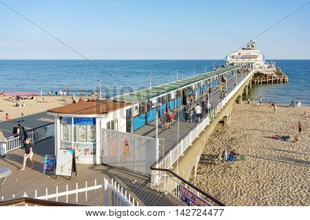 Bournemouth/UK. 14th August 2016. Day trippers enjoy the warm sunshine of Bournemouth Pier and beach at dusk.