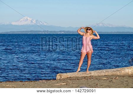 Young woman on beach by sea. Centennial Beach at Boundary Bay Regional Park Tsawwassen British Columbia Canada.