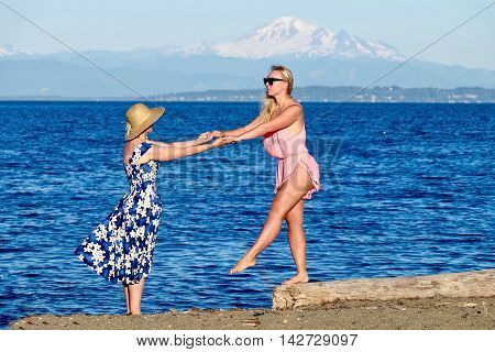 Mother and daughter on beach. Centennial Beach at Boundary Bay Regional Park Tsawwassen British Columbia Canada.