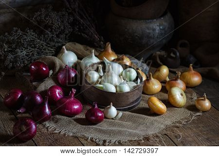 Yellow red and white onions on a wooden surface. Rusic style