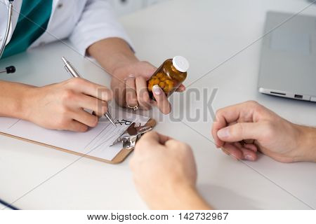 Close-up View Of Female Doctor Hand Holding Bottle With Pills