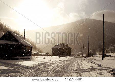 Snowy misty village street in Siberia in winter