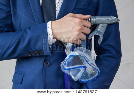 Businessman holding snorkeling goggle in white background - business vacation concept
