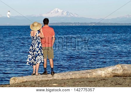 Man and woman on beach by blue sea. Centennial Beach at Boundary Bay Regional Park Tsawwassen British Columbia Canada.