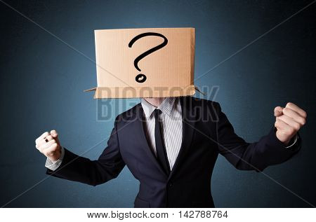 Businessman standing and gesturing with a cardboard box on his head with question mark