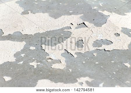 Stone colored old and cracked paint. Foreground and background are blurred.