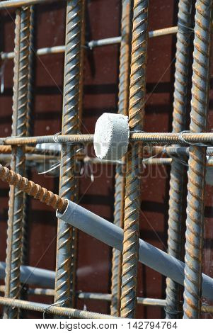 SELANGOR, MALAYSIA -SEPTEMBER 19, 2015: Hot rolled deformed steel bars or steel reinforcement bar and the concrete spacer. The spacer used to created gap between reinforcement bar and the form work.