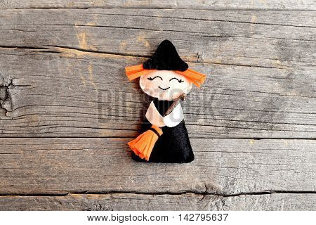 Halloween cute felt witch with broom on old wooden background. Halloween little witch ornament crafts for kids. Handicraft felt decor. Tutorial. Step. Top view