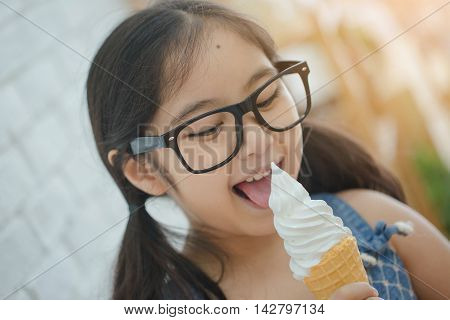 Happy Asian girl enjoy eating soft ice-cream