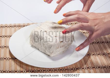 White plate with halvah, table, board, bamboo