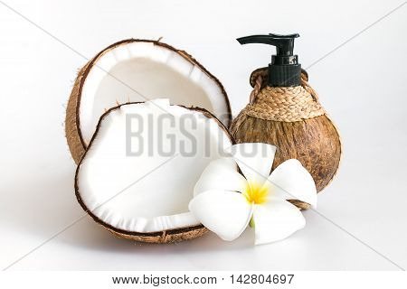 Coconut and coconut oil botton with plumeria or frangipani flower isolated on white background