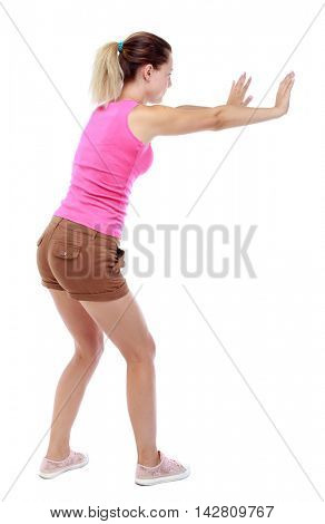back view of woman pushes wall.  Isolated over white background. Rear view people collection. backside view of person. Sport blond in brown shorts shows stop sign.
