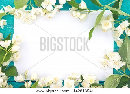Frame Of Mock-orange Flowers On Turquoise Rustic Wooden Background With Empty Card For Greeting Mess