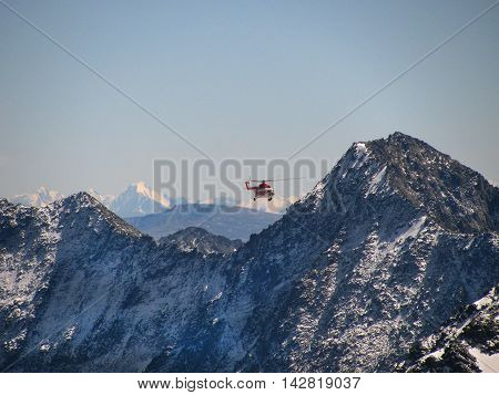 Helicopter flying in the background of snowy mountains