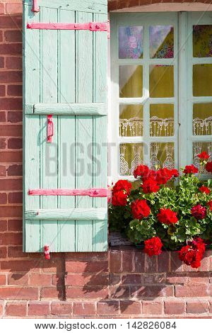 Window with wooden shutters decorated with flowers