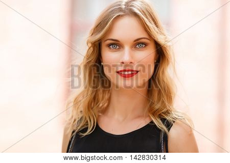 Outdoors closeup portrait of blonde woman with grey eyes and natural makeup