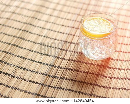Cold lemonade with ice placed on wooden with burst light