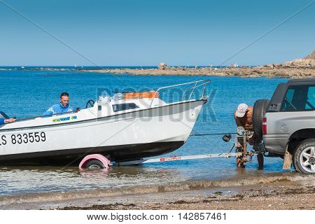 Men Getting Boats Out Of Water With Car On The Beach