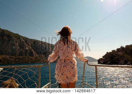 Woman stading ahead on a bow of the boat with beautiful sea scenery